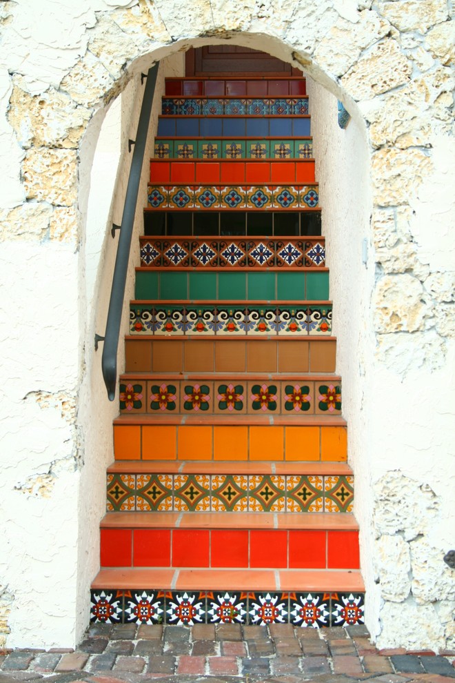 This is an example of an eclectic terracotta straight staircase in Miami with tile risers.