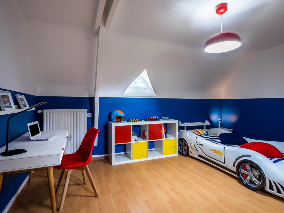 This is an example of a mid-sized scandinavian kids' bedroom for kids 4-10 years old and boys in Other with blue walls and laminate floors.