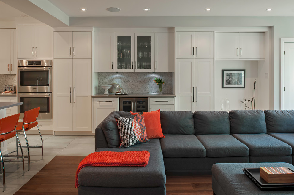 Inspiration for a large modern open concept family room in Toronto with a home bar, grey walls, medium hardwood floors, brown floor, a ribbon fireplace, a tile fireplace surround and a wall-mounted tv.