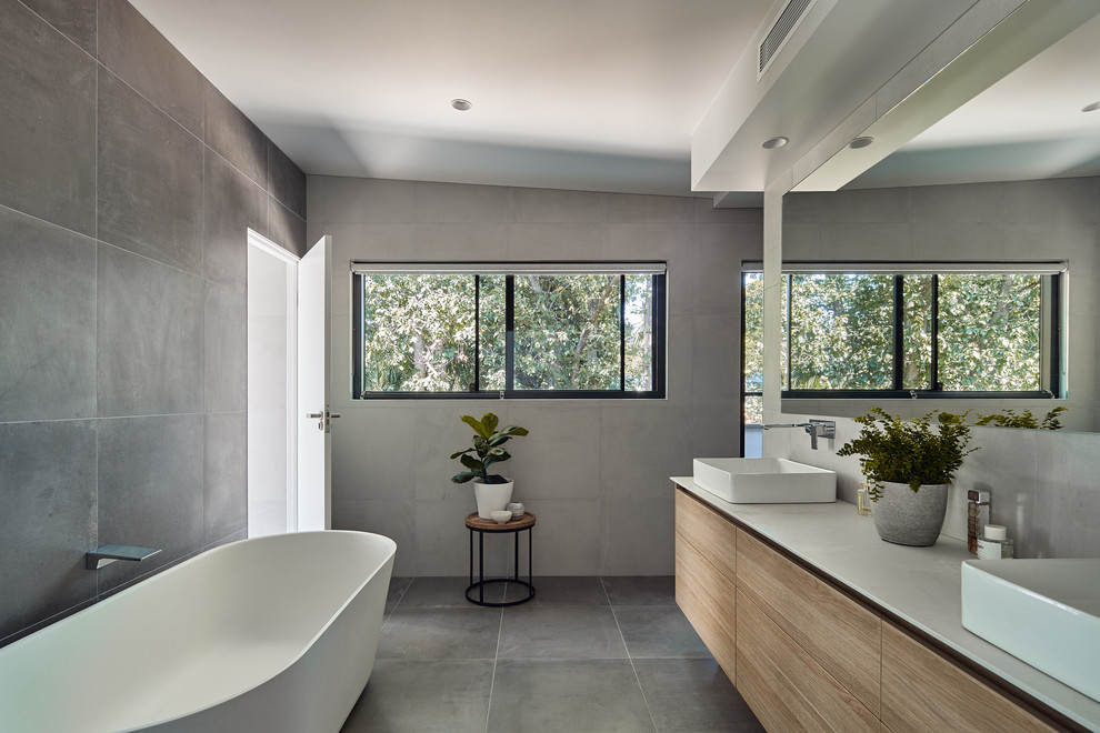 Photo of a small contemporary master bathroom in Melbourne with a freestanding tub, gray tile, cement tile, ceramic floors, a vessel sink, concrete benchtops, grey floor and grey benchtops.
