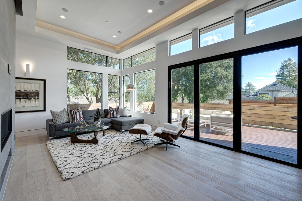 Inspiration for a large contemporary open concept living room in San Francisco with white walls, light hardwood floors, a ribbon fireplace, a concrete fireplace surround and no tv.