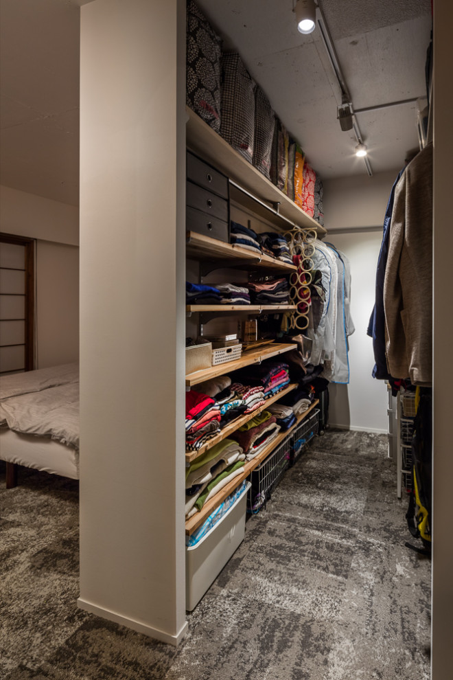 This is an example of a small modern gender-neutral walk-in wardrobe in Yokohama with open cabinets, carpet, grey floor and exposed beam.