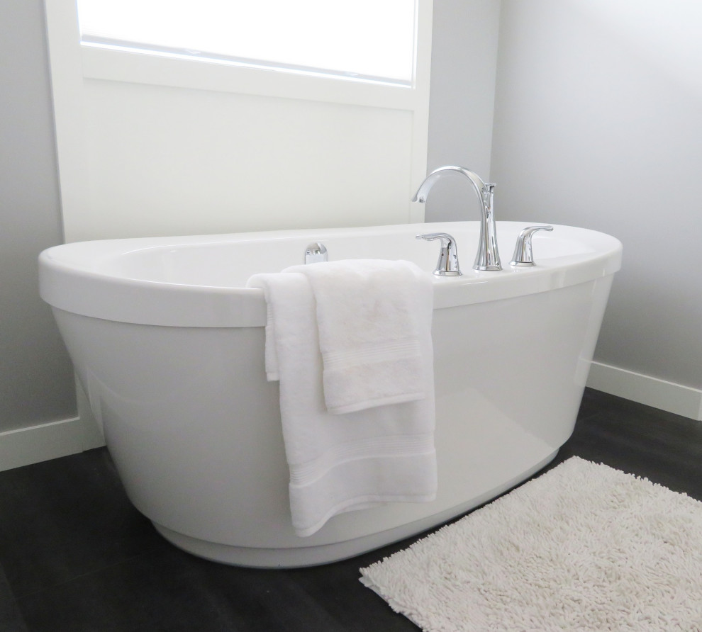 Ispirazione per una piccola stanza da bagno contemporanea con vasca freestanding, pareti grigie e pavimento marrone