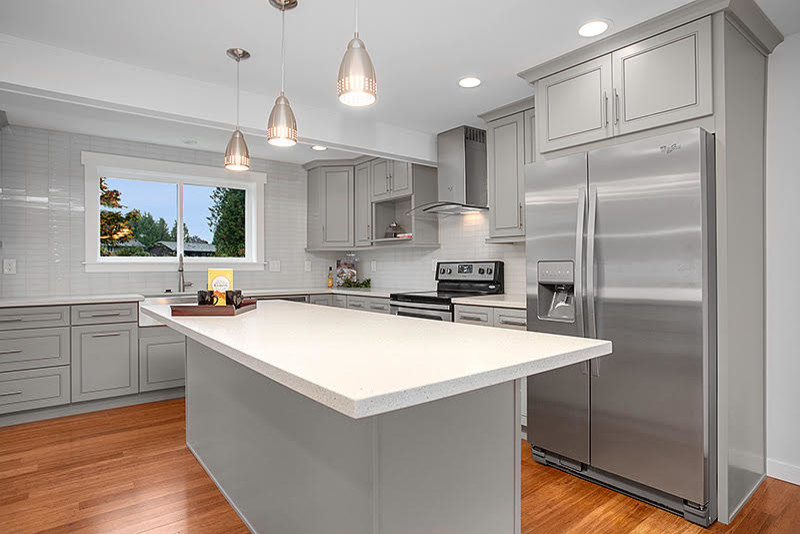 Inspiration for a transitional medium tone wood floor eat-in kitchen remodel in Seattle with raised-panel cabinets, gray cabinets, quartzite countertops, white backsplash, glass tile backsplash, stainless steel appliances and an island