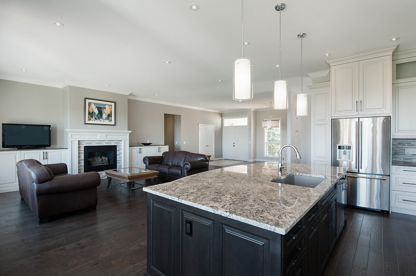 Example of a large transitional l-shaped dark wood floor open concept kitchen design in Calgary with an undermount sink, raised-panel cabinets, white cabinets, granite countertops, multicolored backsplash, matchstick tile backsplash, stainless steel appliances and an island