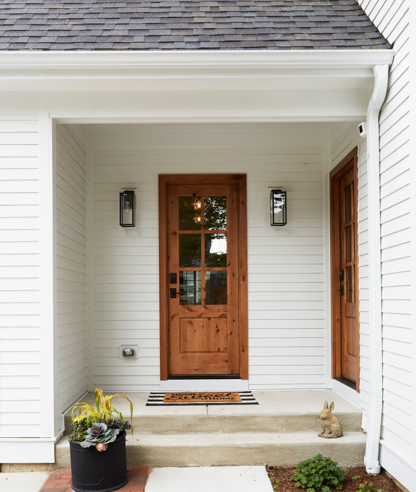 Foto di un ingresso con anticamera country di medie dimensioni con pareti bianche, pavimento in mattoni, una porta singola, una porta in legno bruno e pavimento grigio