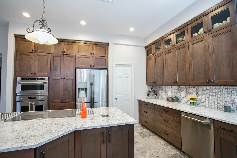 Inspiration for a porcelain tile kitchen remodel in Phoenix with an undermount sink, shaker cabinets, gray cabinets, quartz countertops, white backsplash, ceramic backsplash, stainless steel appliances and an island