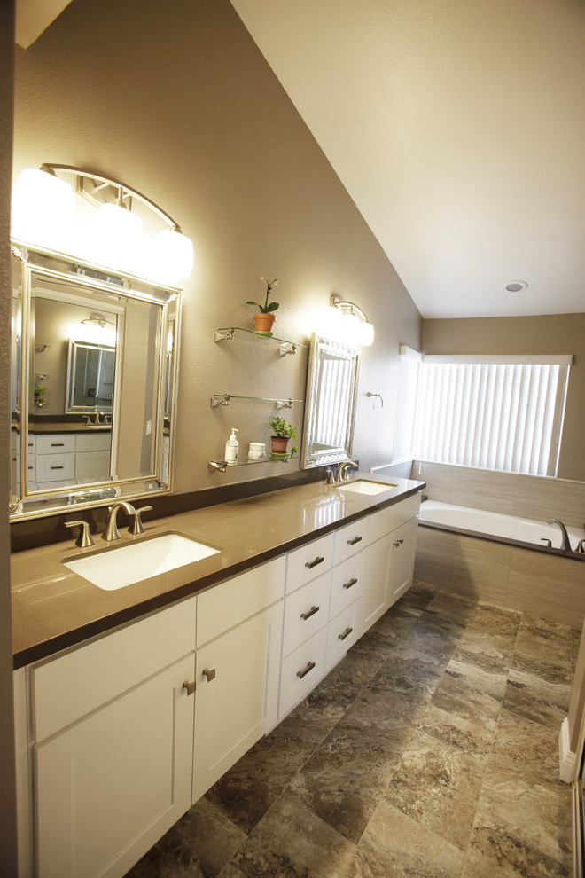 Design ideas for a large transitional master bathroom in Los Angeles with recessed-panel cabinets, white cabinets, a drop-in tub, brown walls, porcelain floors, an undermount sink, solid surface benchtops and a corner shower.