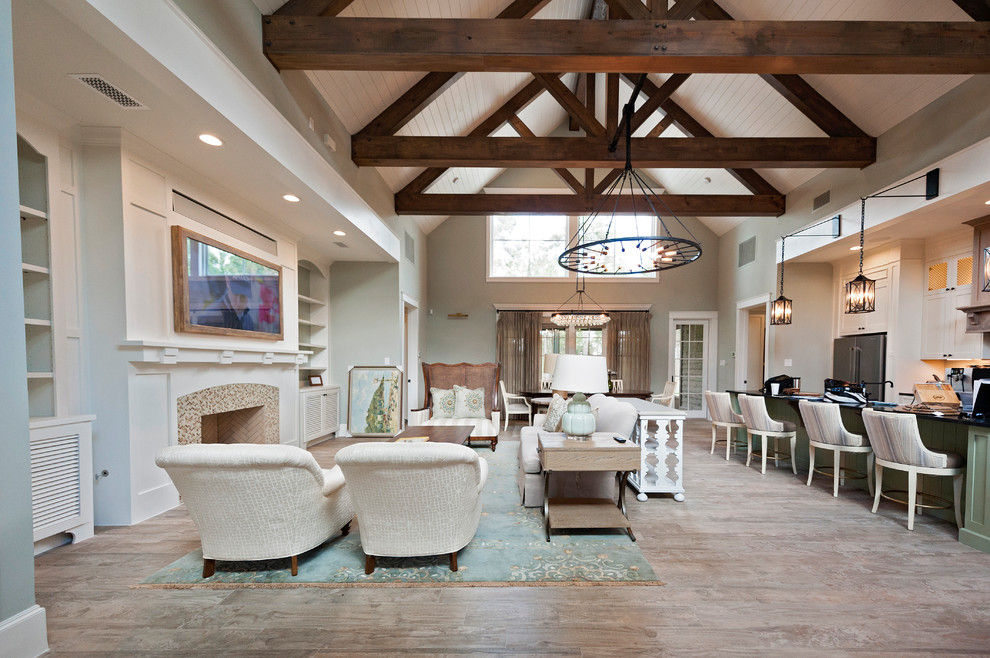 Inspiration for an expansive beach style open concept family room in Houston with medium hardwood floors, a standard fireplace, a tile fireplace surround, brown floor, blue walls, a built-in media wall and exposed beam.