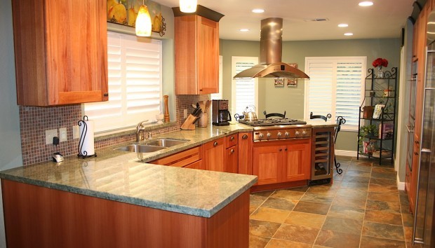 Inspiration for a mid-sized transitional u-shaped slate floor kitchen remodel with an undermount sink, recessed-panel cabinets, medium tone wood cabinets, granite countertops, green backsplash, stone tile backsplash, stainless steel appliances and no island