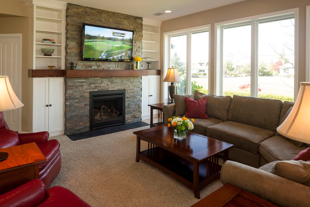 This is an example of a mid-sized traditional open concept family room in Portland with beige walls, carpet, a standard fireplace, a stone fireplace surround and a wall-mounted tv.
