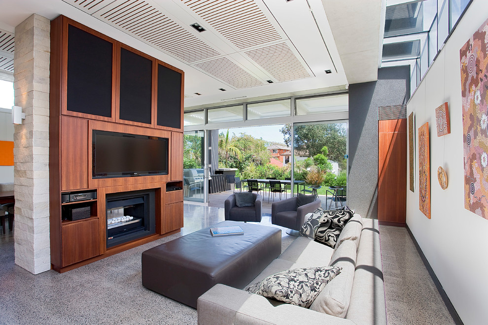 Large contemporary open concept living room in Sydney with concrete floors, a two-sided fireplace, a built-in media wall, grey floor and white walls.