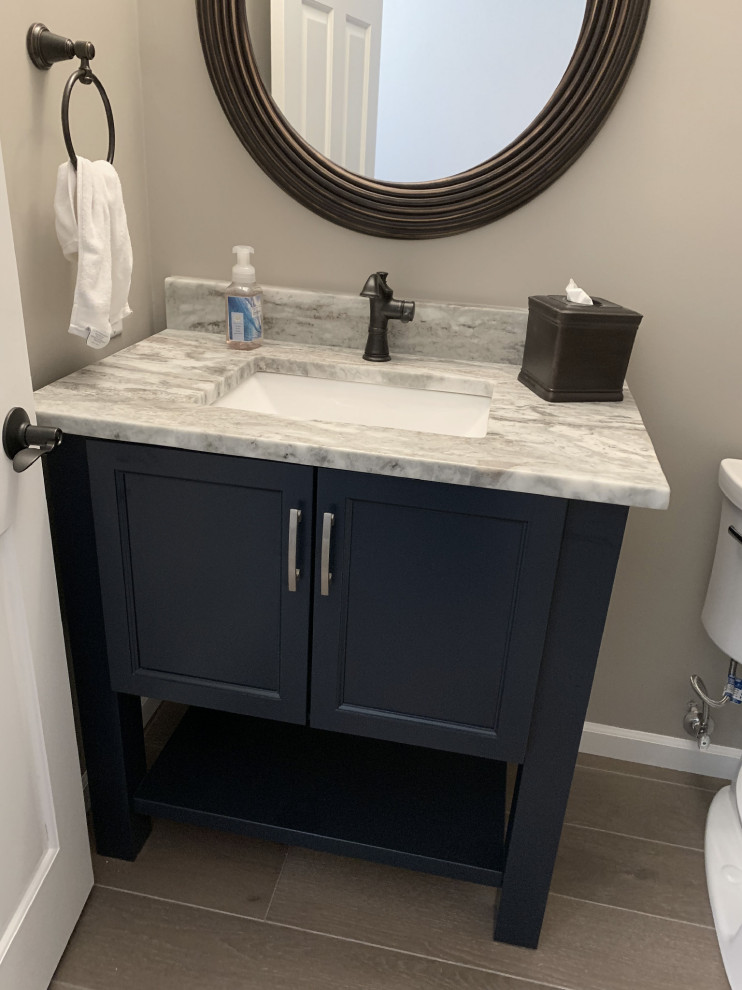 Inspiration for a small transitional vinyl floor and gray floor bathroom remodel with furniture-like cabinets, blue cabinets, a two-piece toilet, gray walls, an undermount sink, quartz countertops and multicolored countertops