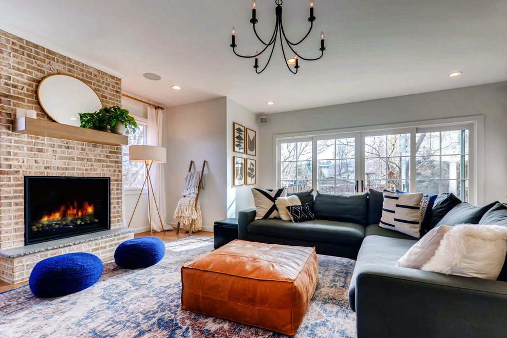 Mid-sized traditional open concept family room in Denver with white walls, light hardwood floors, a standard fireplace, a brick fireplace surround and brown floor.