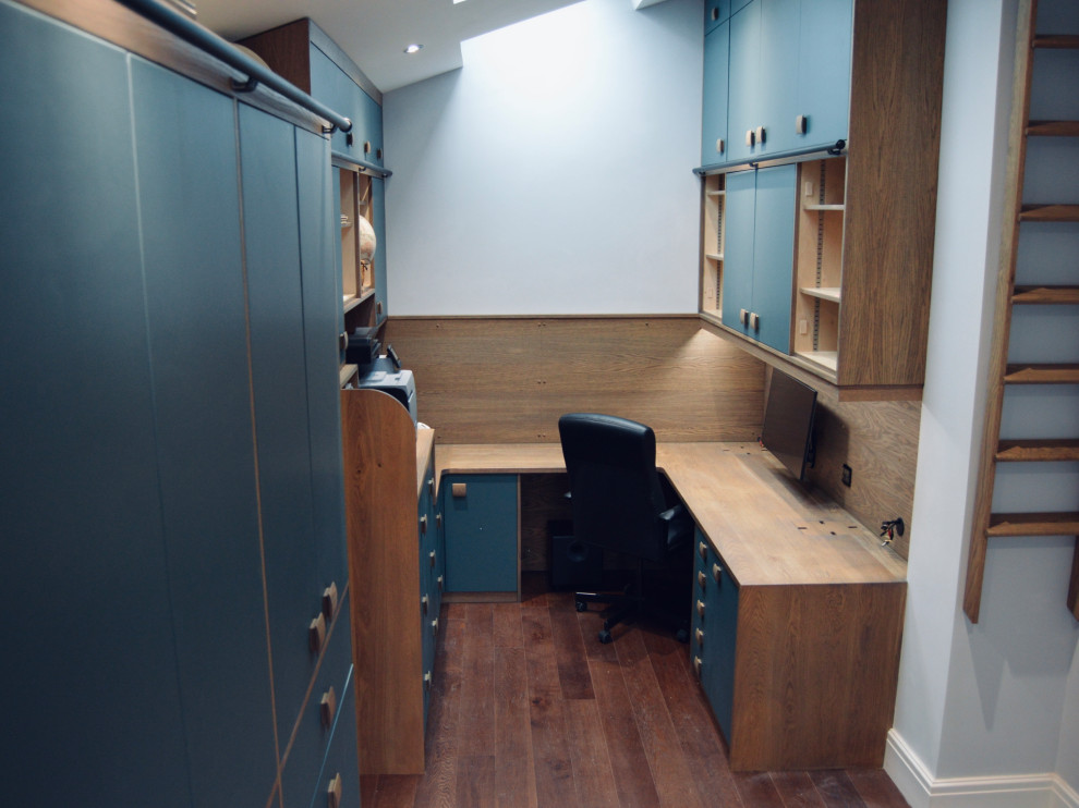 Mittelgroßes Modernes Arbeitszimmer mit Arbeitsplatz, weißer Wandfarbe, dunklem Holzboden, Einbau-Schreibtisch und braunem Boden in Cardiff