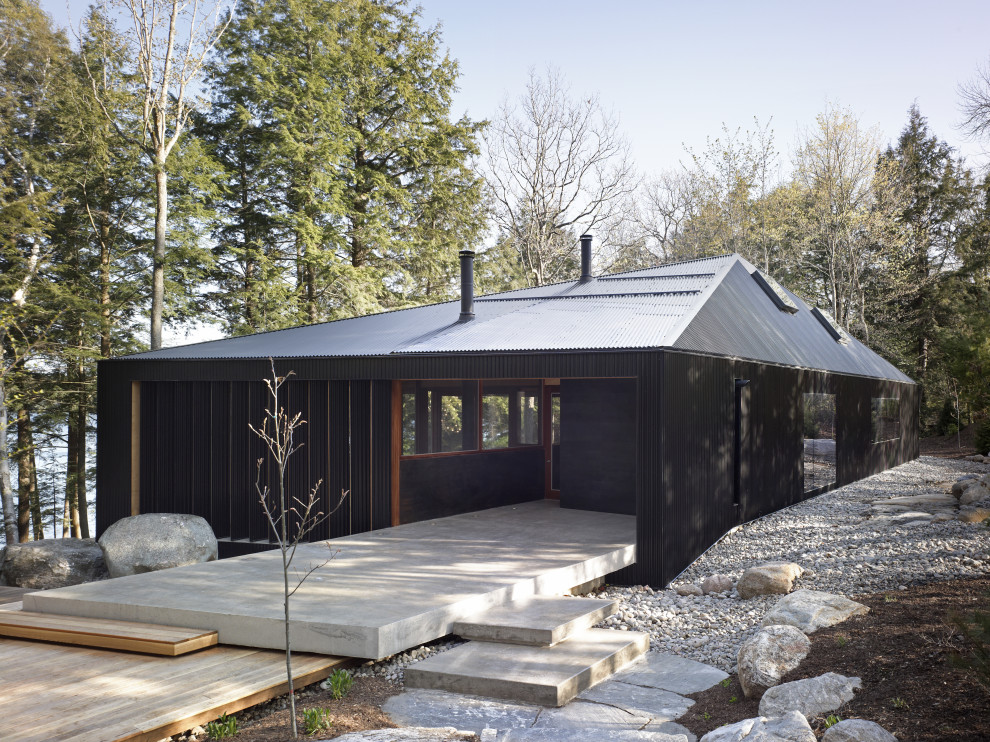 Design ideas for a large contemporary one-storey black house exterior in Toronto with a hip roof, a metal roof, a black roof and board and batten siding.