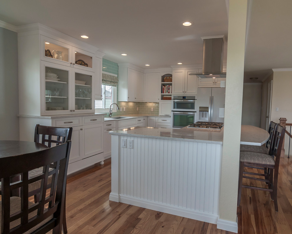 Mid-sized transitional medium tone wood floor eat-in kitchen photo in Denver with a single-bowl sink, flat-panel cabinets, yellow cabinets, quartz countertops, blue backsplash, glass tile backsplash, white appliances and an island