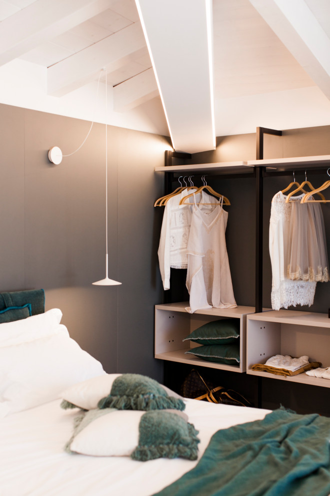 Imagen de armario y vestidor minimalista grande con armarios abiertos, puertas de armario beige, suelo de travertino, suelo beige y vigas vistas