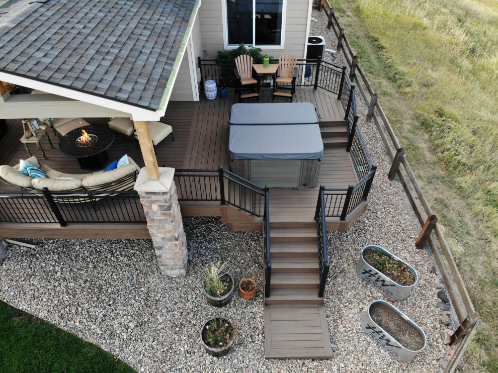 Design ideas for a mid-sized transitional backyard and first floor deck in Denver with a fire feature, a roof extension and metal railing.