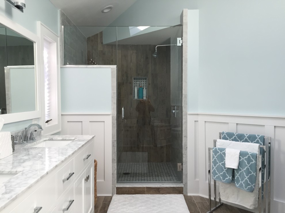 Design ideas for a large transitional master bathroom in New York with recessed-panel cabinets, white cabinets, an alcove shower, blue walls, vinyl floors, an undermount sink, marble benchtops and a hinged shower door.