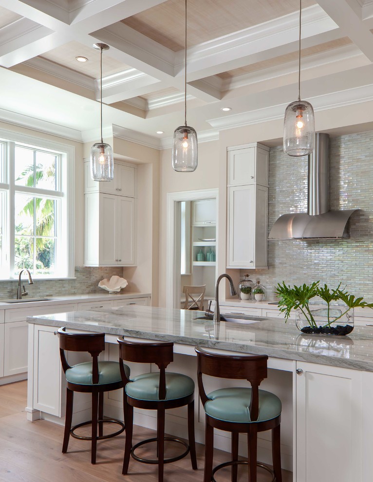 Example of a large transitional galley light wood floor eat-in kitchen design in Miami with an undermount sink, flat-panel cabinets, beige cabinets, quartzite countertops, gray backsplash, glass tile backsplash, stainless steel appliances and an island