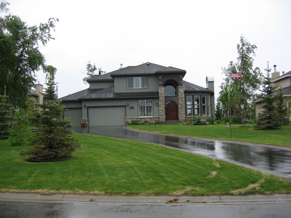 Photo of a mid-sized traditional two-storey green exterior in Other with vinyl siding and a hip roof.