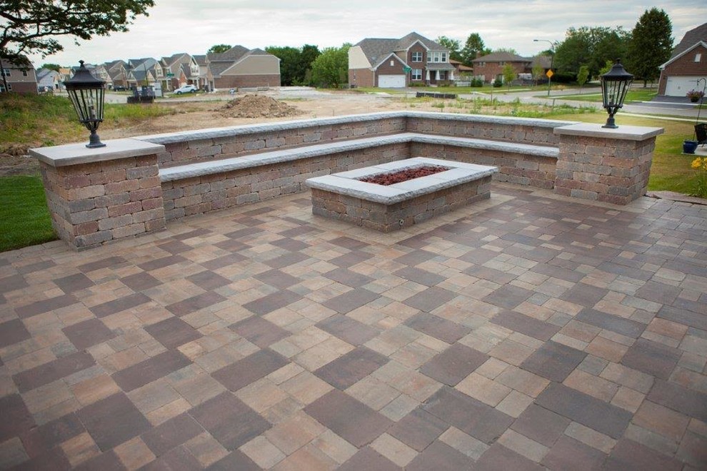 Design ideas for a mid-sized traditional backyard patio in Chicago with brick pavers and a pergola.