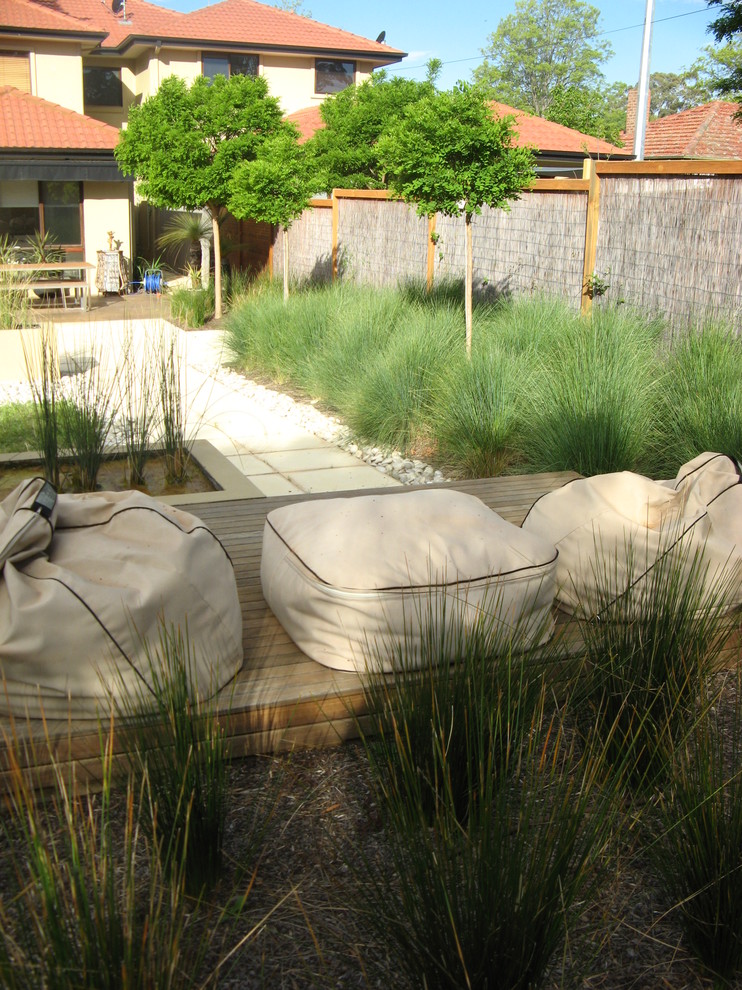 Inspiration for a small contemporary full sun xeriscape for spring in Canberra - Queanbeyan with a water feature and natural stone pavers.