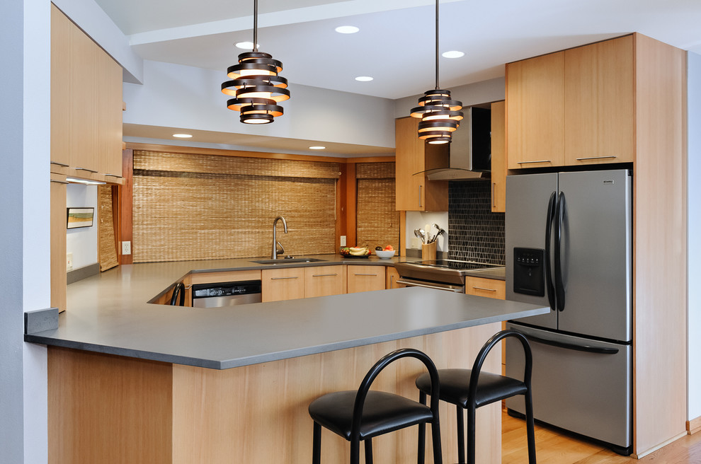 Inspiration for a small contemporary kitchen in Portland with an undermount sink, flat-panel cabinets, light wood cabinets, black splashback, stainless steel appliances, medium hardwood floors and a peninsula.