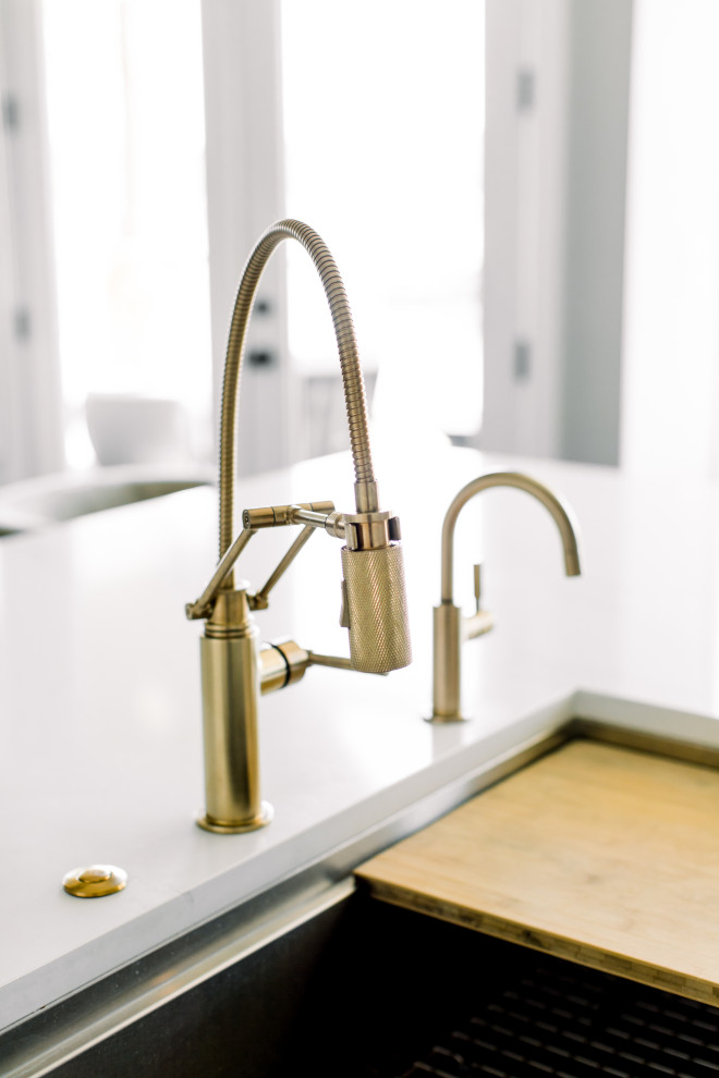 Example of a mid-sized transitional single-wall dark wood floor, brown floor and exposed beam eat-in kitchen design with an undermount sink, shaker cabinets, white cabinets, quartz countertops, white backsplash, subway tile backsplash, stainless steel appliances, an island and white countertops