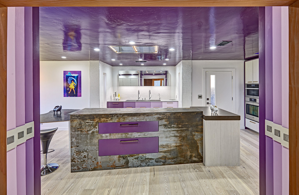 Photo of a large modern l-shaped separate kitchen in Sacramento with an undermount sink, flat-panel cabinets, purple cabinets, quartz benchtops, white splashback, porcelain splashback, stainless steel appliances, light hardwood floors and with island.