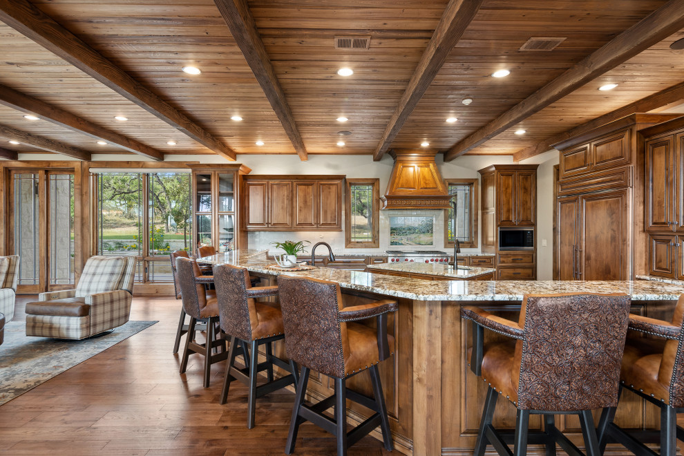 Transitional wood ceiling kitchen photo in Austin with raised-panel cabinets, medium tone wood cabinets, granite countertops, an island, brown countertops and an undermount sink