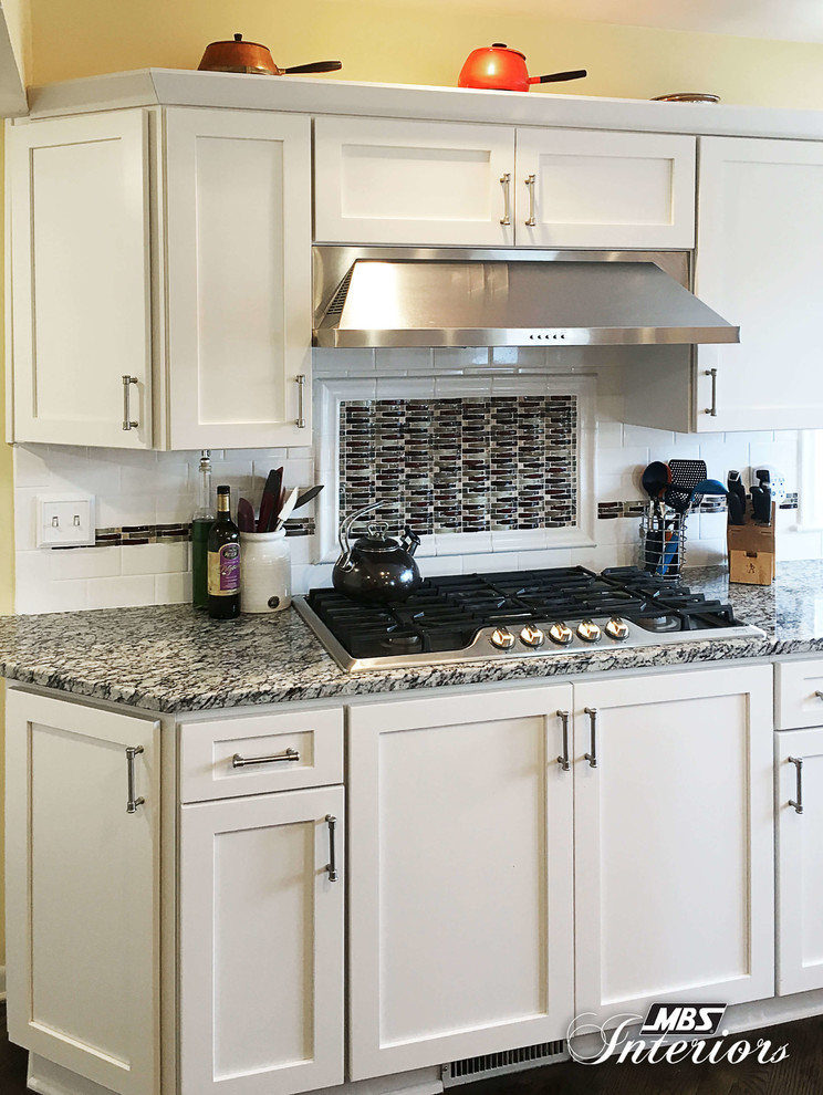 Example of a huge transitional u-shaped medium tone wood floor and brown floor eat-in kitchen design with an undermount sink, shaker cabinets, white cabinets, granite countertops, white backsplash, subway tile backsplash, stainless steel appliances and an island