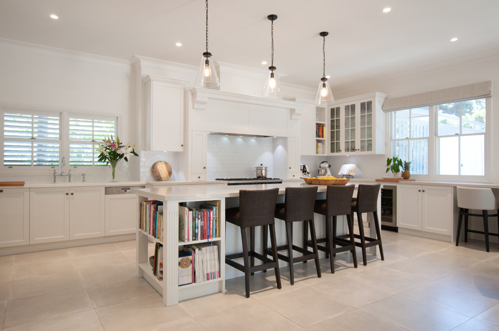 Expansive traditional u-shaped open plan kitchen in Sydney with an undermount sink, shaker cabinets, white cabinets, quartz benchtops, white splashback, subway tile splashback, stainless steel appliances, ceramic floors and with island.