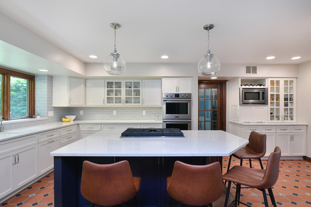 Inspiration for a large transitional u-shaped porcelain tile and orange floor eat-in kitchen remodel with a double-bowl sink, recessed-panel cabinets, white cabinets, quartz countertops, blue backsplash, subway tile backsplash, stainless steel appliances, an island and gray countertops