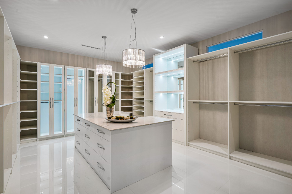 Photo of a large transitional gender-neutral storage and wardrobe in Miami with beaded inset cabinets, light wood cabinets, marble floors and white floor.