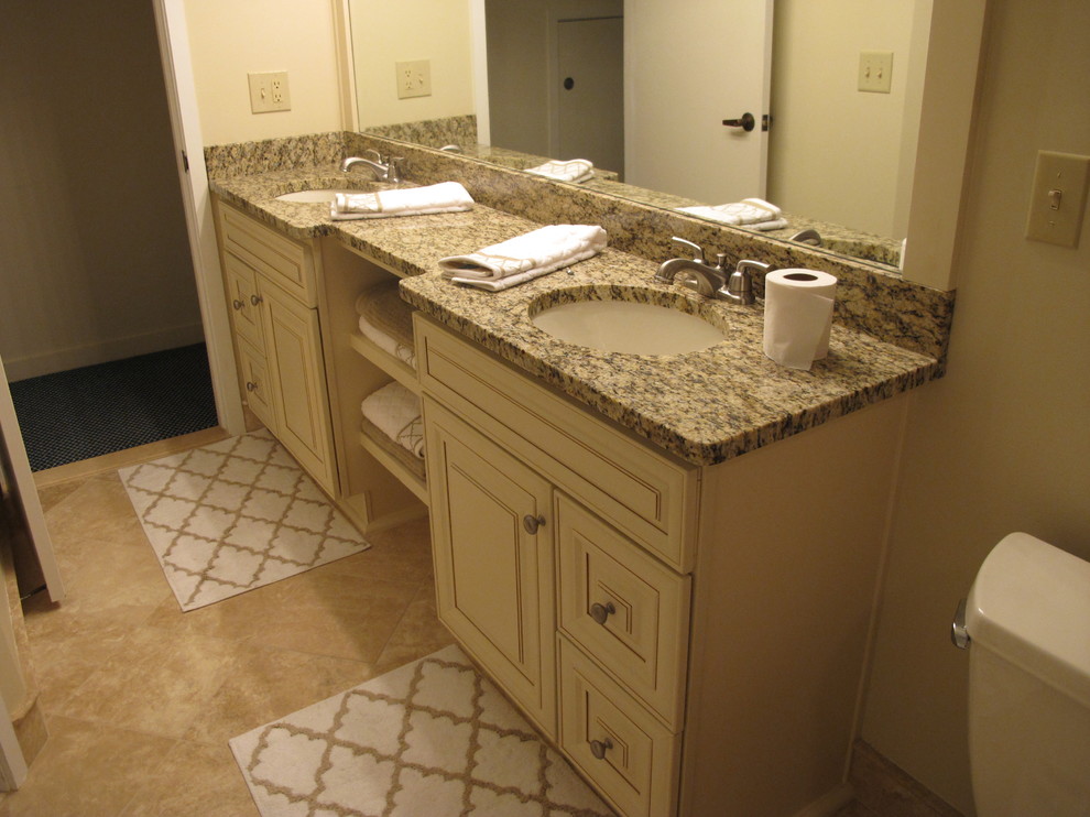 Alcove bathtub - mid-sized transitional beige tile and stone tile porcelain tile alcove bathtub idea with an undermount sink, raised-panel cabinets, white cabinets, marble countertops and beige walls