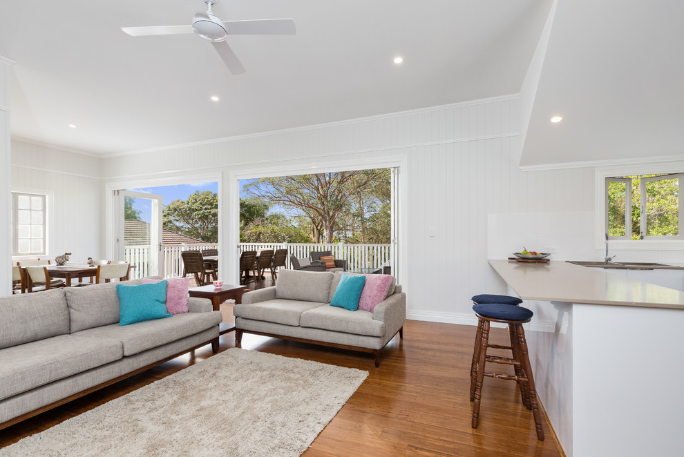 This is an example of a mid-sized beach style formal enclosed living room in Brisbane with beige walls, bamboo floors and a freestanding tv.
