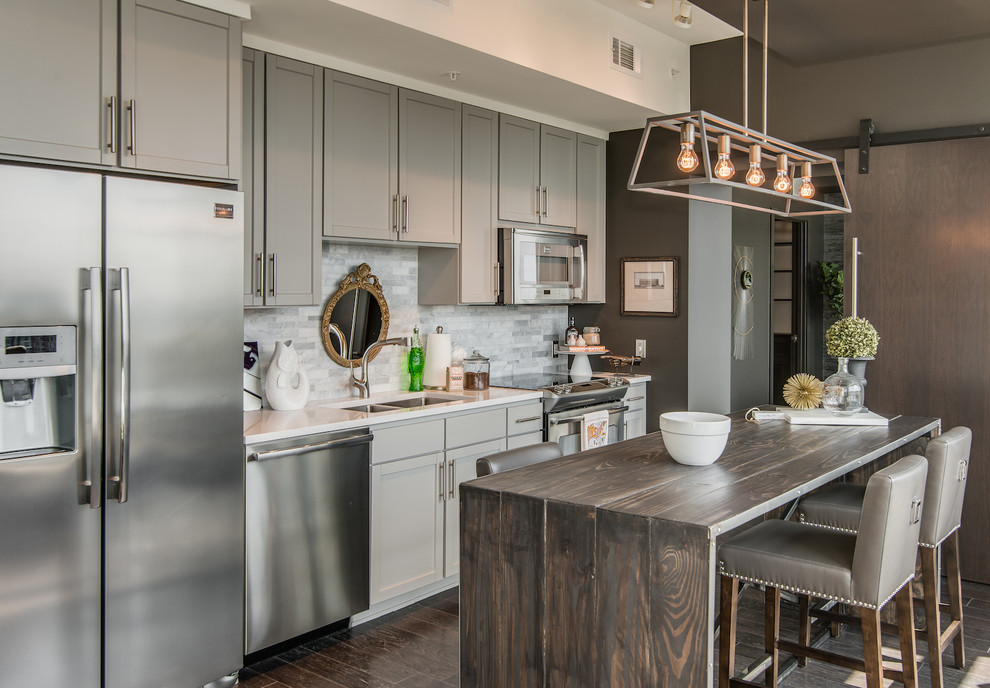 Design ideas for a transitional galley kitchen in Nashville with an undermount sink, shaker cabinets, grey cabinets, wood benchtops, white splashback, stainless steel appliances, dark hardwood floors and with island.