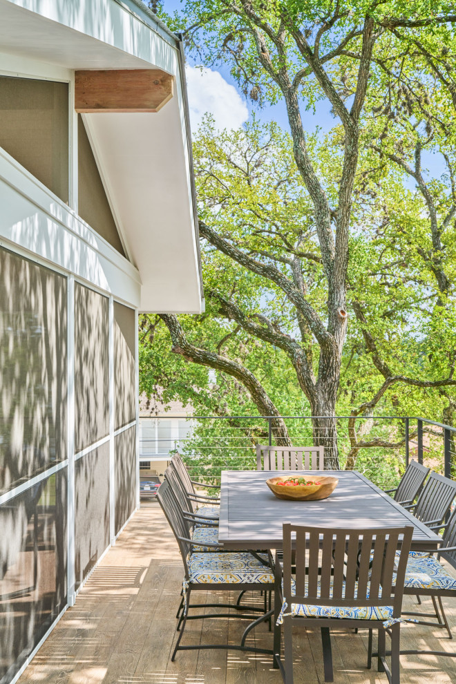 This is an example of a contemporary back wire cable railing veranda in Austin.