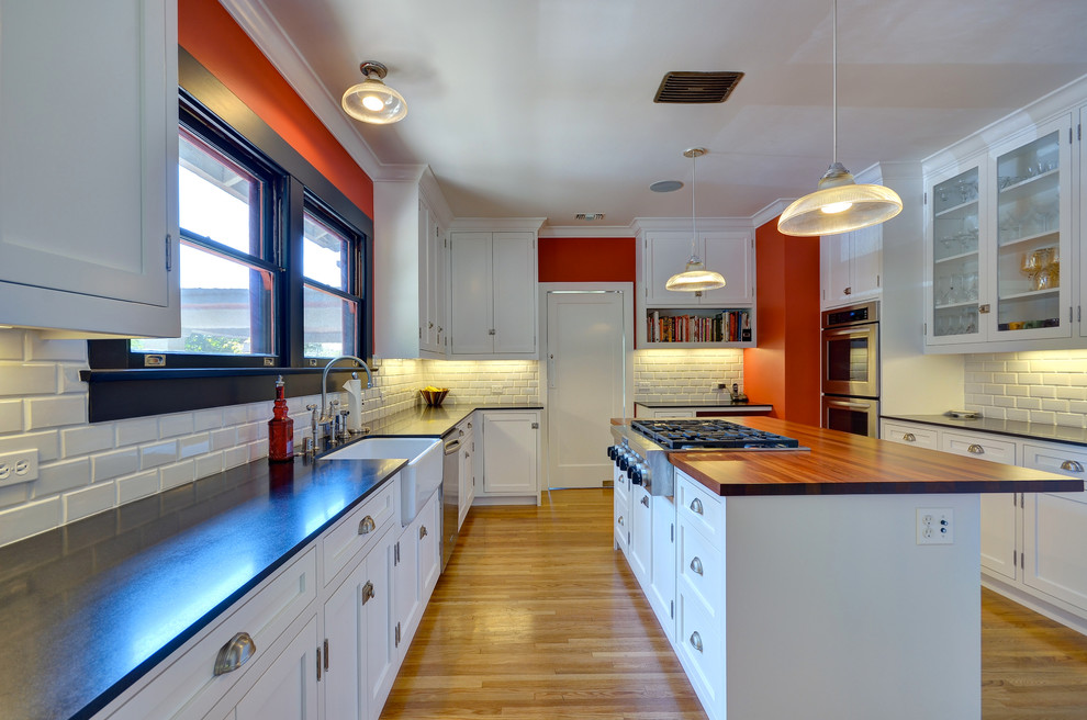 Kitchen - contemporary kitchen idea with a farmhouse sink, wood countertops, shaker cabinets, white cabinets, white backsplash, subway tile backsplash and stainless steel appliances