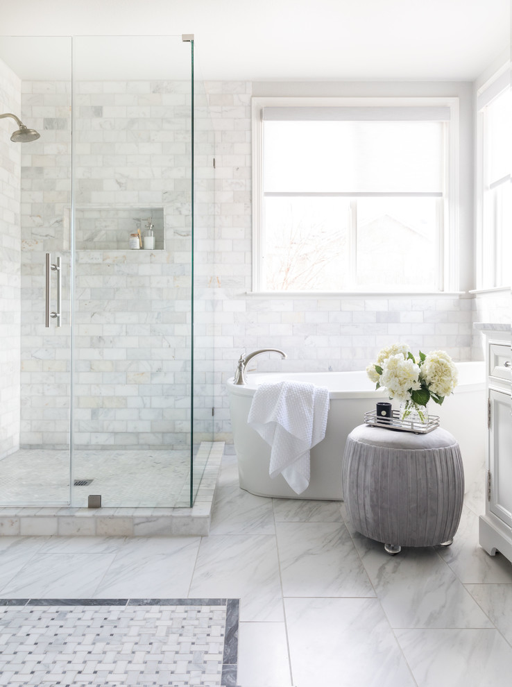 Design ideas for a mid-sized transitional master bathroom in Sacramento with shaker cabinets, white cabinets, a freestanding tub, white tile, marble, grey walls, marble floors, an undermount sink, marble benchtops, white floor, a hinged shower door and white benchtops.