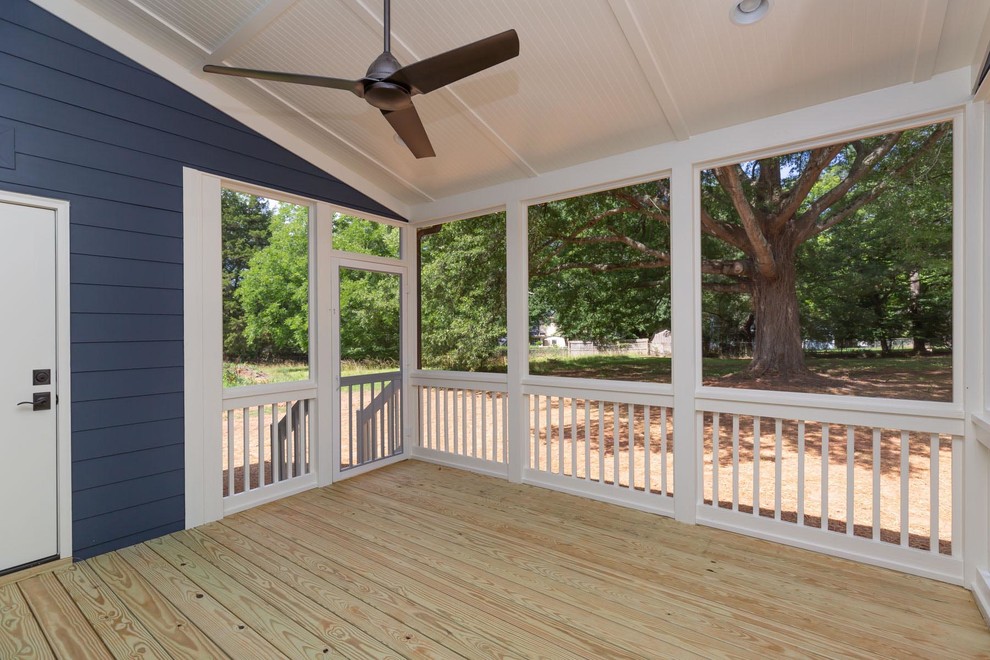 This is an example of a mid-sized traditional backyard screened-in verandah in Raleigh with decking and a roof extension.