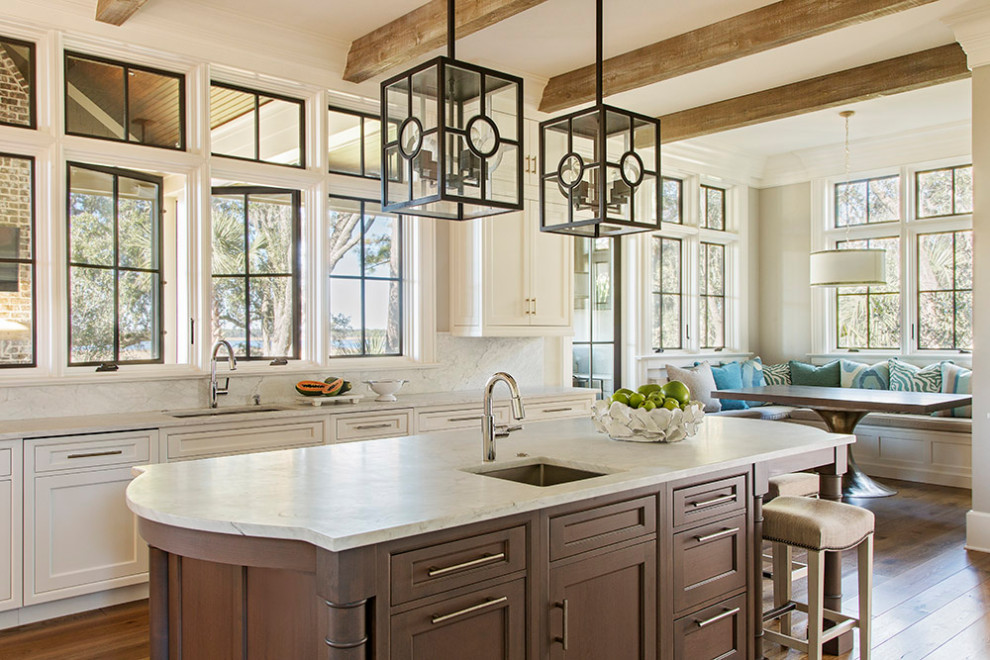 Beach style eat-in kitchen in Charleston with an undermount sink, shaker cabinets, white cabinets, white splashback, stone tile splashback, medium hardwood floors, with island, white benchtop and exposed beam.