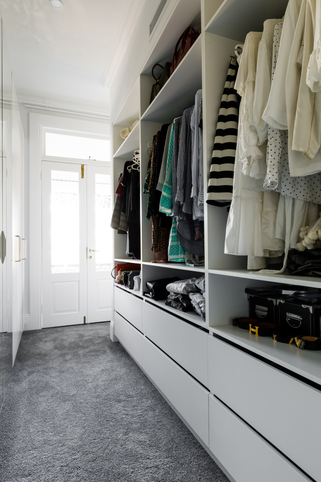 Small contemporary gender-neutral storage and wardrobe in London with white cabinets, carpet and grey floor.