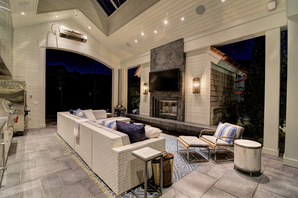 This is an example of a large transitional backyard patio in Salt Lake City with a roof extension, an outdoor kitchen and concrete pavers.