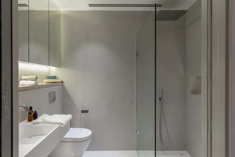 Design ideas for a small modern master bathroom in London with recessed-panel cabinets, grey cabinets, an open shower, a wall-mount toilet, gray tile, porcelain tile, grey walls, cement tiles, a wall-mount sink, concrete benchtops, grey floor, an open shower and grey benchtops.