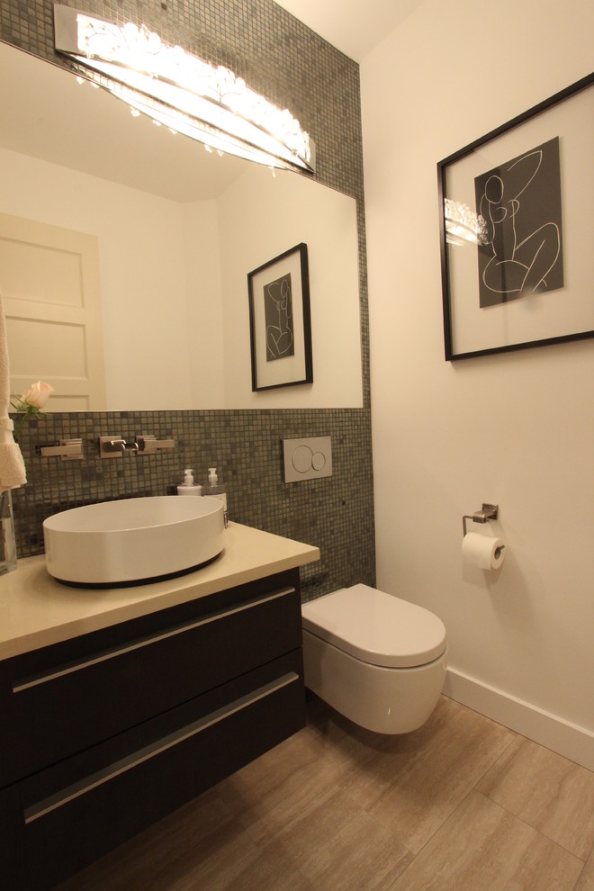 This is an example of a contemporary powder room in Seattle with flat-panel cabinets, dark wood cabinets, engineered quartz benchtops, a wall-mount toilet, glass tile, white walls and porcelain floors.