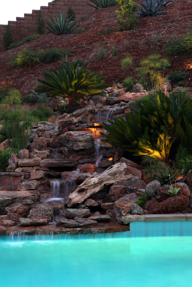 Großer Rustikaler Gartenwasserfall hinter dem Haus mit direkter Sonneneinstrahlung und Natursteinplatten in San Diego