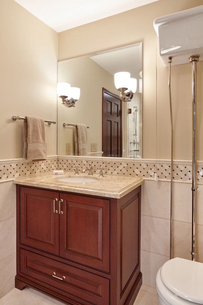 Photo of a small traditional 3/4 bathroom in San Francisco with gray tile, marble, marble floors, an undermount sink, marble benchtops, beige walls, beaded inset cabinets, brown cabinets, an alcove shower and a two-piece toilet.